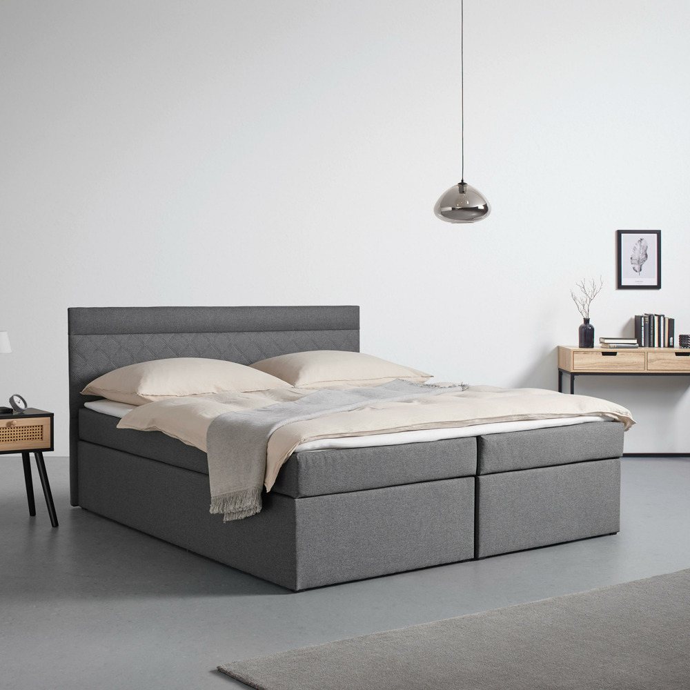 Tento výrobek je k dispozici POUZE ONLINE. Tato atraktivní tmavě šedá boxspring postel poskytuje elegantní a pohodlný prostor na spaní pro váš domov. Lůžko s látkovým potahem a čtvercovým čelem postele s decentními švy je vybaveno