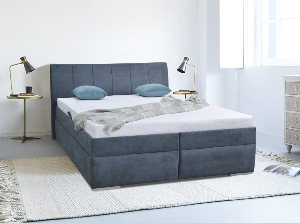 Komfortní dvoulůžková postel se zvýšeným sedem a s úložným prostorem. Součástí postele je rošt. Nosnost